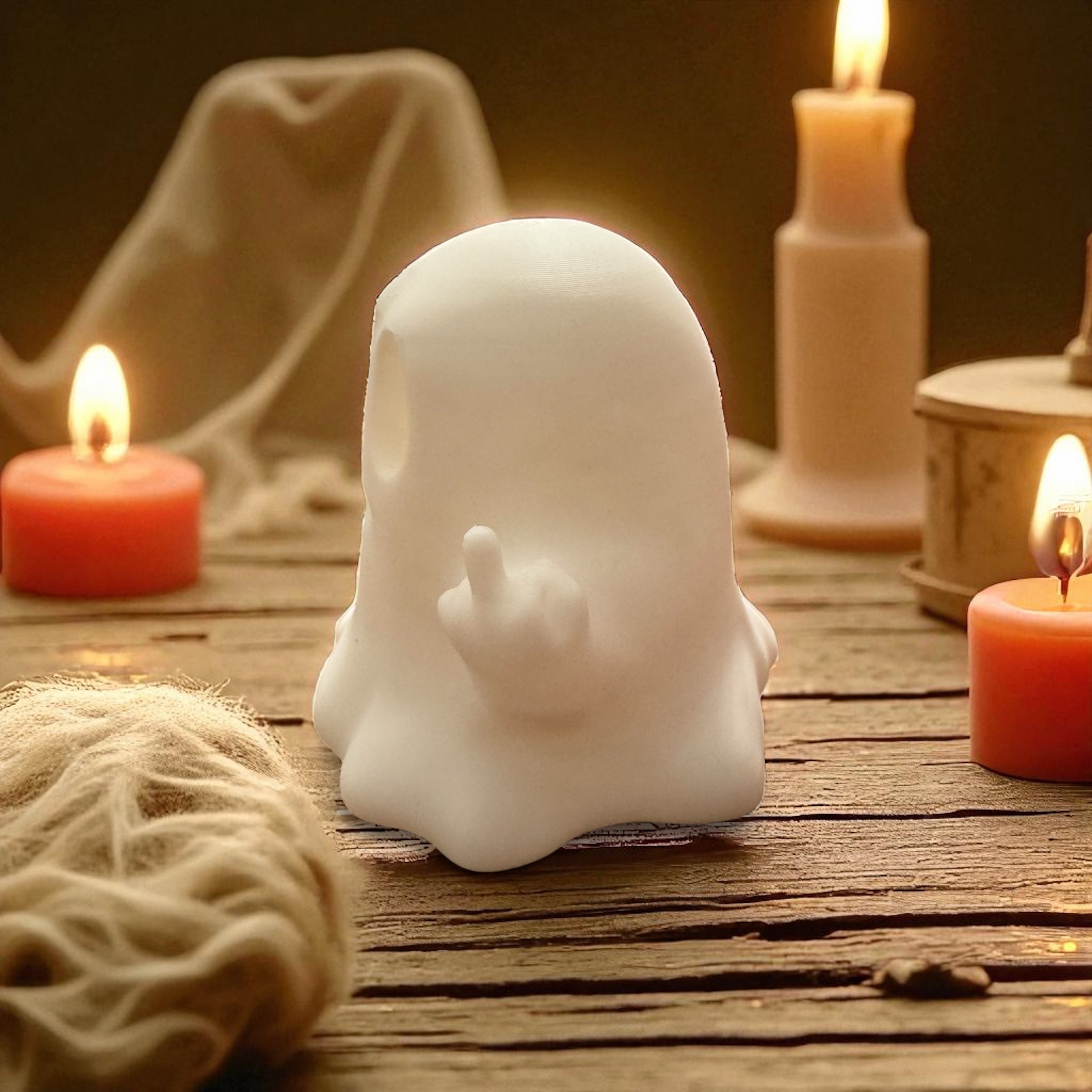 White ghost-shaped candle on a wooden surface with lit candles in the background